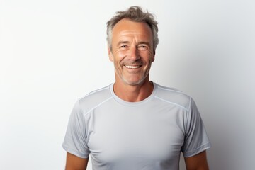 Wall Mural - Portrait of a smiling man in his 50s sporting a breathable mesh jersey in front of white background