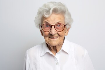 Wall Mural - Portrait of a jovial elderly 100 year old woman wearing a classic white shirt in front of white background