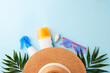 Beach vacation setup featuring sunscreen, sunglasses, and a straw hat on a bright blue background, perfectly staged for summer product promotions or editorial features