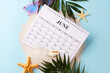 June calendar amidst beach-themed elements, suggesting the perfect time to plan for summer vacations. It is an excellent visual for seasonal marketing campaigns