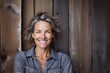 © CogniLens - Portrait of a smiling woman in her 40s wearing a comfy flannel shirt on rustic wooden wall