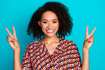 Poster - Photo of charming girly lady wear print shirt showing two v-signs empty space isolated blue color background