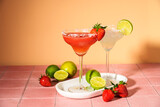 Fototapeta  - Margarita alcohol cocktail. Classic and strawberry margaritas with tequila and lime at sunny summer background.