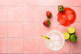 Fototapeta  - Classic and strawberry margaritas with tequila and lime at color background. Top view on pink tile.