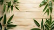 Fresh green bamboo leaves naturally arranged over a light wooden plank background, offering a serene and vibrant look.