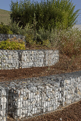 Sticker - Gabion de galets dans un espace vert	