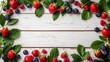 Fresh summer berries arranged on a white rustic wooden background, with plenty of copy space.