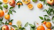 Fresh assorted citrus fruits with leaves spread on a white background, creating a frame with copy space.