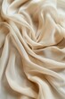 © Business Image - Beige satin fabric draped in smooth folds, creating an elegant texture. Macro textile photography