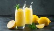 Refreshing lemon smoothie or slushie in tall glasses on dark background
