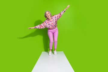 Wall Mural - Full length photo of cheerful sweet lady pink shirt walking promenade arms sides empty space isolated green color background