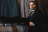 Fototapeta  - Businessman in classic vest against suit jackets, shop store clothes for men