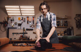 Fototapeta  - Man shoemaker hold different rolls natural leather brown, working with textile in workshop of tailor, banner