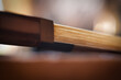 A detailed view of a violin bow against a blurred background, highlighting the craftsmanship