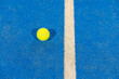 ball next to the line on a blue paddle tennis court