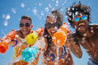 Happy young people are using water guns play in the summer, enjoy the splashing. AI.