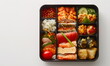 © xuxu - Lunch box on a plain white background. Traditional Asian food in plastic, square, black take-out packaging. Healthy eating, cooking, sushi, seaweed, fish. View from above