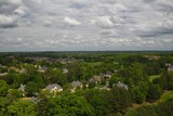 Fototapeta Miasto - Aerial panoramic view of an upscale suburb and lush green landscape in USA shot during early spring of 2024