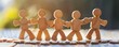 Wooden human figures holding hands on a wooden surface with blurred natural background.
