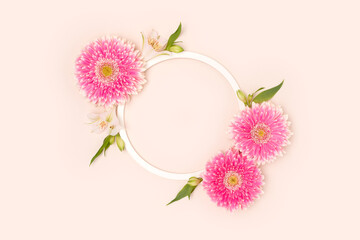 Wall Mural - wreath made of green leaves, alstroemeria and gerbera flowers on a beige background.