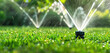 © Klay - automatic sprinkler system watering lush green grass in a vibrant garden at sunset