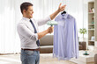 © Ljupco Smokovski - Man using a hand steam iron for a shirt at home