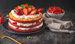 A tantalizing strawberry shortcake, layered with cream and fresh strawberries, ready to be savored. Set against a dark backdrop