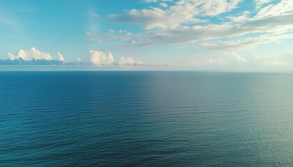 Wall Mural - an aerial view of eternal blue sea or ocean with sunny and cloudy sky