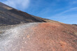 un chemin coloré sur les pentes d'un volcan avec un ciel bleu