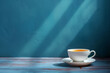 Cup of tea on a saucer with sunlight casting shadows on a blue wall, copy space
