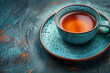 Teacup with tea on matching saucer, on textured surface with copy space