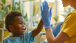 Boy in blue shirt high-fives a healthcare worker in yellow. Pediatric care, cheerful interaction, hospital setting promoting health and wellness. Positive healthcare experience. AI