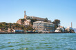Clear day view of Alcatraz Island in San Francisco Bay, California, USA, showcasing the former prison complex with main cellhouse, lighthouse, dock, and historic structures.