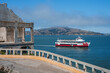 Explore the views of Alcatraz Island with a faded structure and a modern ferry on the San Francisco Bay. Witness history and beauty in one captivating image.