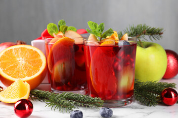 Wall Mural - Aromatic Sangria drink in glasses, ingredients and Christmas decor on white marble table