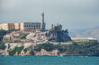 Distant view of Alcatraz Island in San Francisco Bay, USA, known for the infamous former Alcatraz Federal Penitentiary. Rocky terrain, lighthouse, and maritime activities.
