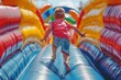 © top images - A young boy runs through a colorful inflatable obstacle course