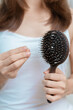 Hair loss problem, Balding , Beauty treatments and health care concepts asian woman holding holding comb with hair loss, young female hold hairbrush and brushing with fall hair from scalp