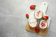 Tasty yoghurt with jam and strawberries on grey table, top view. Space for text