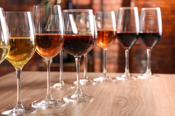 Wall Mural - Different tasty wines in glasses on wooden table, space for text