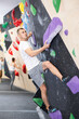 © JackF - Young man in sportswear practicing rock climbing on climbing wall