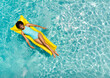 Young biracial woman enjoys a relaxing day on a pool float, with copy space