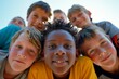 © Iigo - Portrait of group of smiling kids looking at camera against blue sky