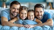 © Kolapatha - A heartwarming image of two Lgbtq fathers and their two daughters smiling and bonding together on a bed, showcasing love, unity, and togetherness in a cozy home setting.