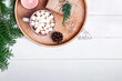 Christmas composition with cocoa with marshmallows, fir branches on the wooden tray