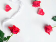 Valentine's day flat lay with red roses and heart shaped candles on white background