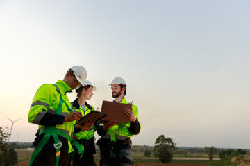 Engineer wearing safety uniform using tablet discussed plan about renewable energy at station energy power wind turbine. technology protect environment reduce global warming problems.