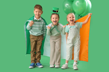 Poster - Cute kids with balloons and flag of Ireland on green background. St. Patrick's Day celebration