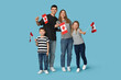 © Pixel-Shot - Beautiful family with flags of Canada on blue background