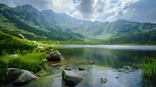 A View Of The Green Mountains And Lake In Poland, With Rocks And Grass Around It